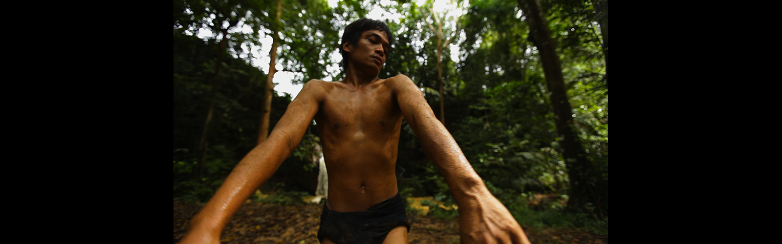 Man dancing in jungle with no shirt